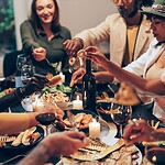 Die 10 nervigsten Sprüche gegen Veganer und die souveräne Antwort Menschen sitzen an einem Esstisch und diskutieren angeregt beim Essen