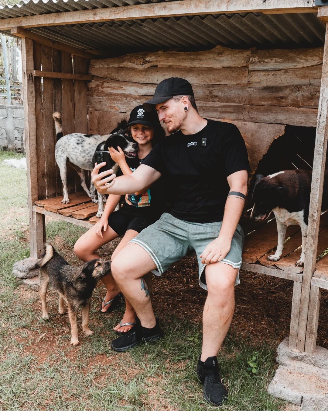 Yannick und Mia Healing machen ein Selfie mit mehreren geretteten Hunden in ihrem Tierheim auf Bali