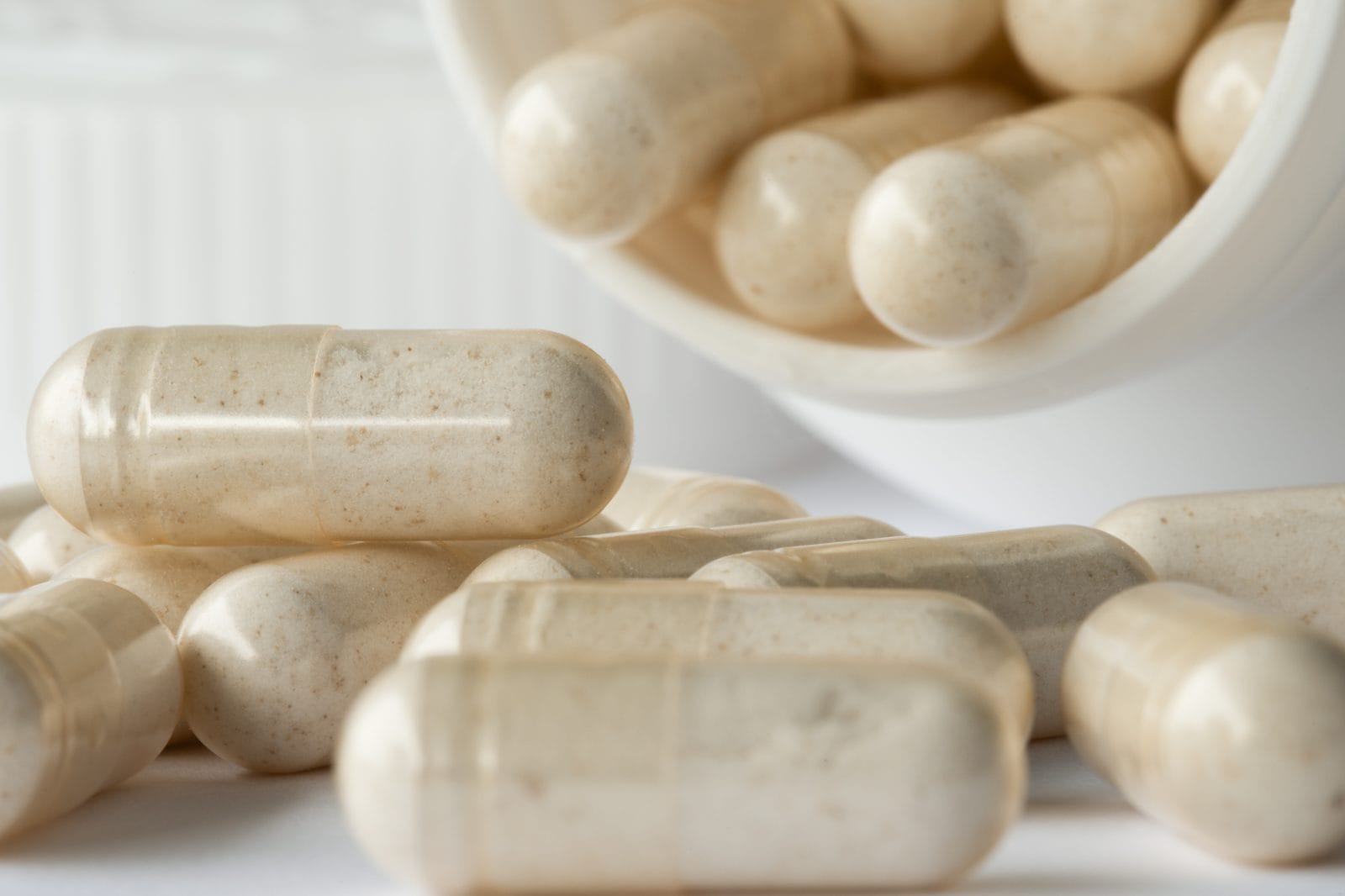 Supplement capsules spilling from a bottle