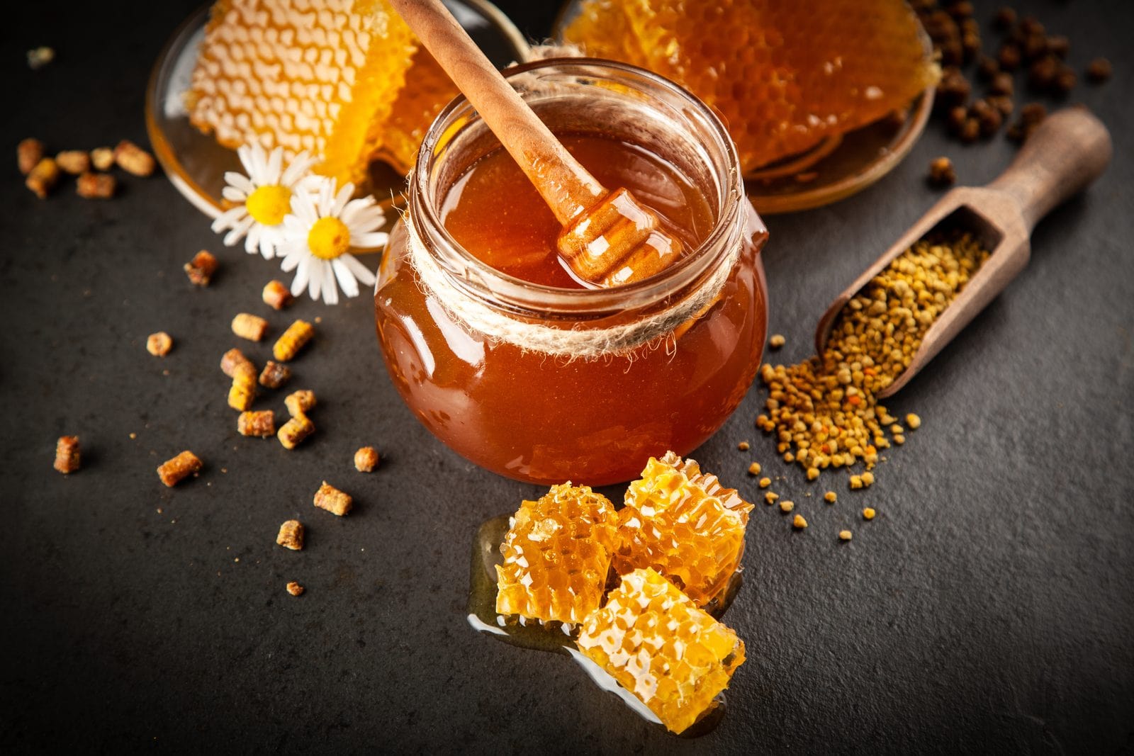 A jar of honey with a wooden dipper