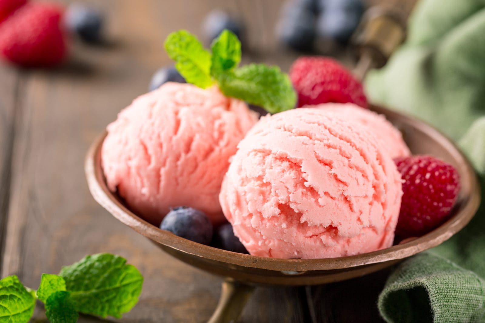 Scoops of ice cream in a bowl with berries