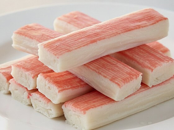 Sticks of imitation crab meat arranged on a plate