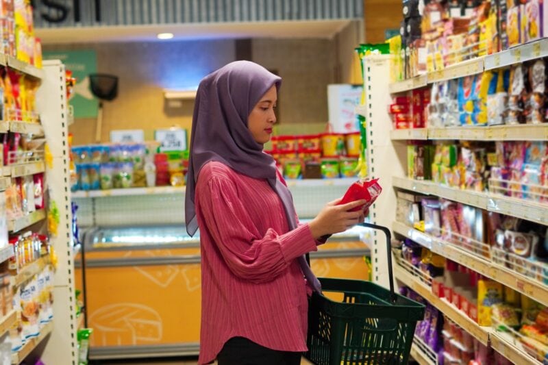 Frau prueft ein Produkt im Supermarkt