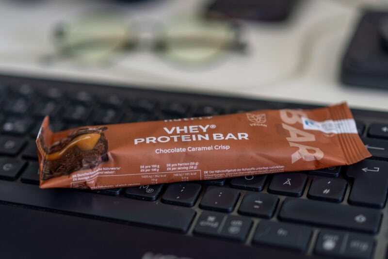 Veganer Proteinriegel: Nutri+ Vhey Bar Chocolate Caramel Crisp auf dem Schreibtisch