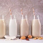 Pflanzliche Milch: Welcher Drink für was wirklich funktioniert Verschiedene pflanzliche Milchsorten in Glasflaschen