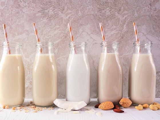 Verschiedene pflanzliche Milchsorten in Glasflaschen