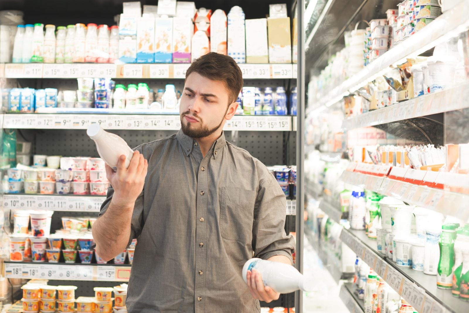 A shopper reading a product label in a supermarket