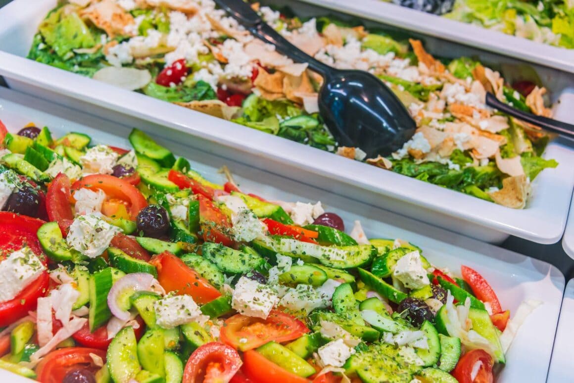 Frische bunte Gemüsesalate mit Tomaten, Gurken und Oliven an einem Buffet