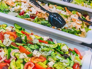 Frische bunte Gemüsesalate mit Tomaten, Gurken und Oliven an einem Buffet
