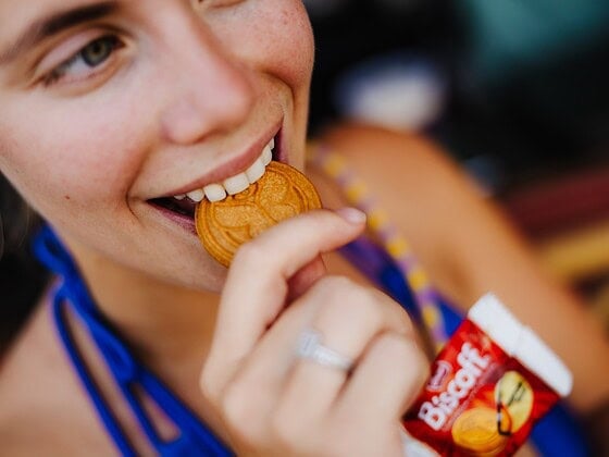 Festivalbesucherin beißt in einen Biscoff-Keks in Medaillen-Form bei Tomorrowland