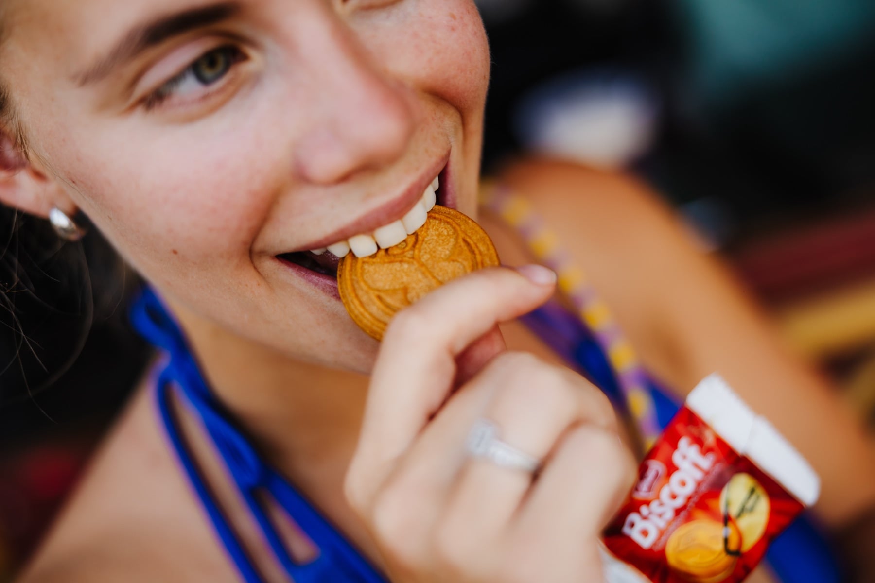Festivalbesucherin beißt in einen Biscoff-Keks in Medaillen-Form bei Tomorrowland