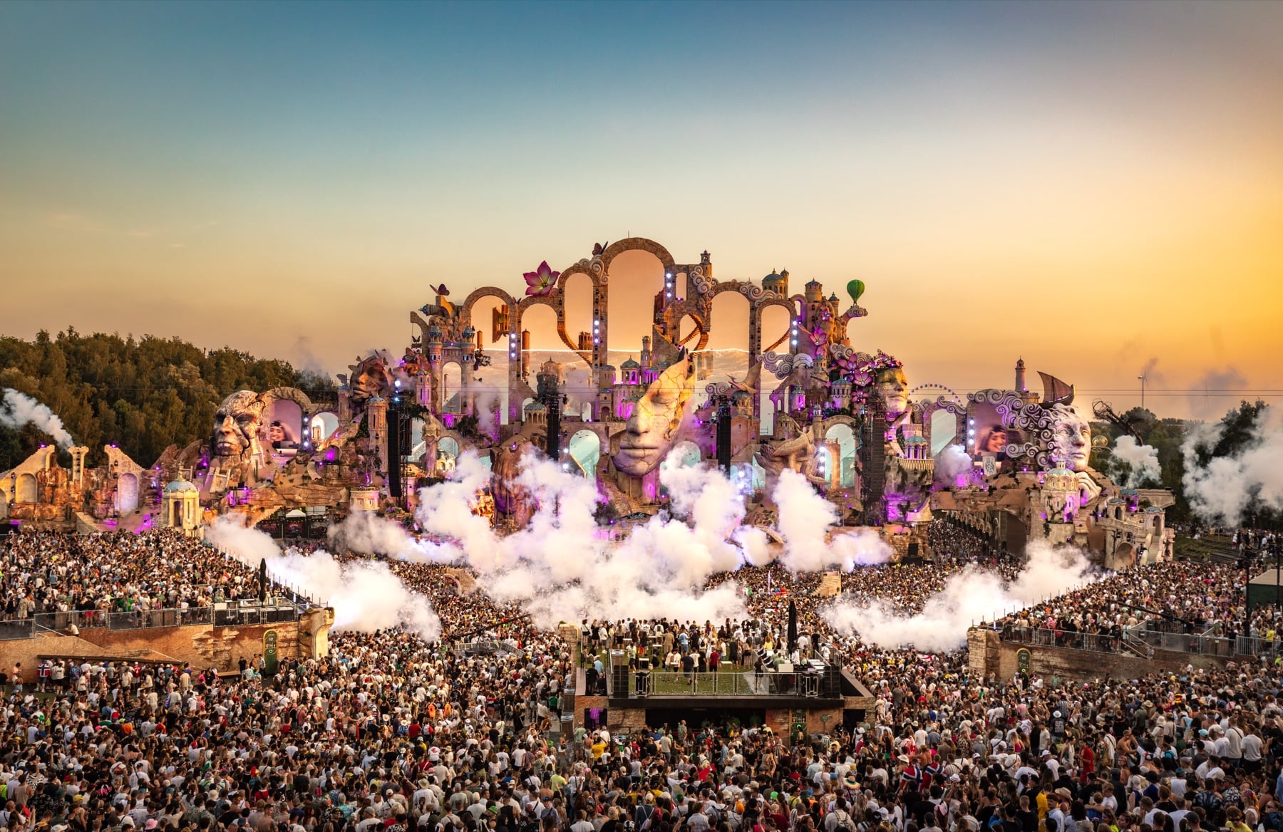 Tomorrowland-Mainstage im Sonnenuntergang mit Nebelschwaden über der Menschenmenge