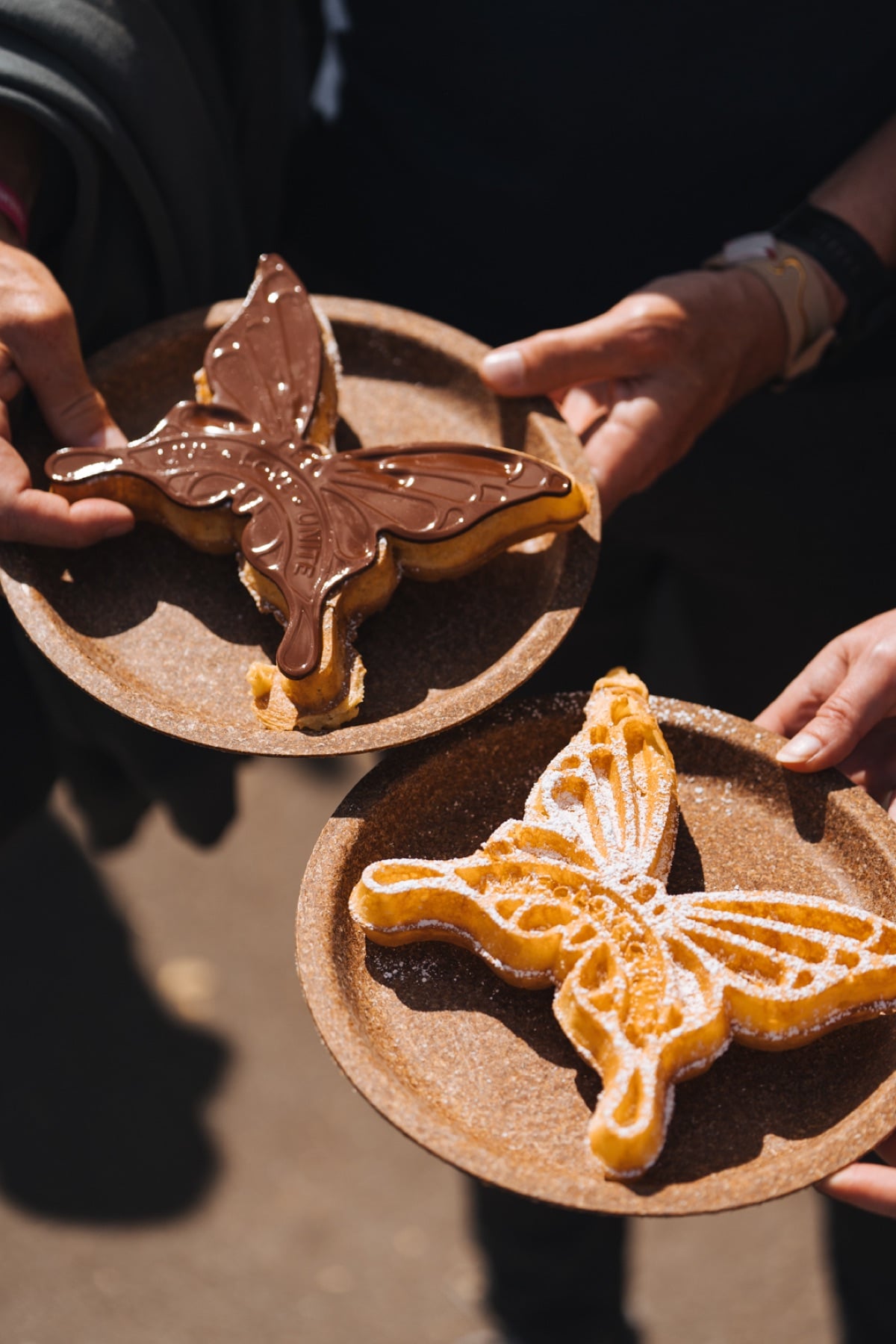 Zwei Waffeln in Schmetterlingsform mit Schokolade und Puderzucker auf Tellern bei Tomorrowland
