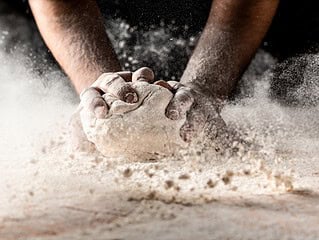 Haende mit Mehl beim Backen