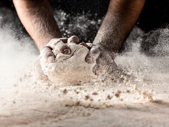 Haende mit Mehl beim Backen