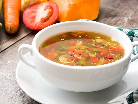 Vegane Gemuesesuppe in einer Schale auf einem Holztisch