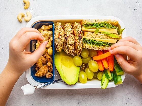 Gesunde Snackbox mit Obst und Avocado