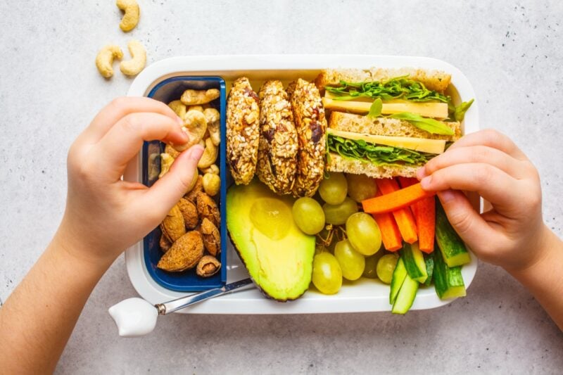 Gesunde Snackbox mit Obst und Avocado