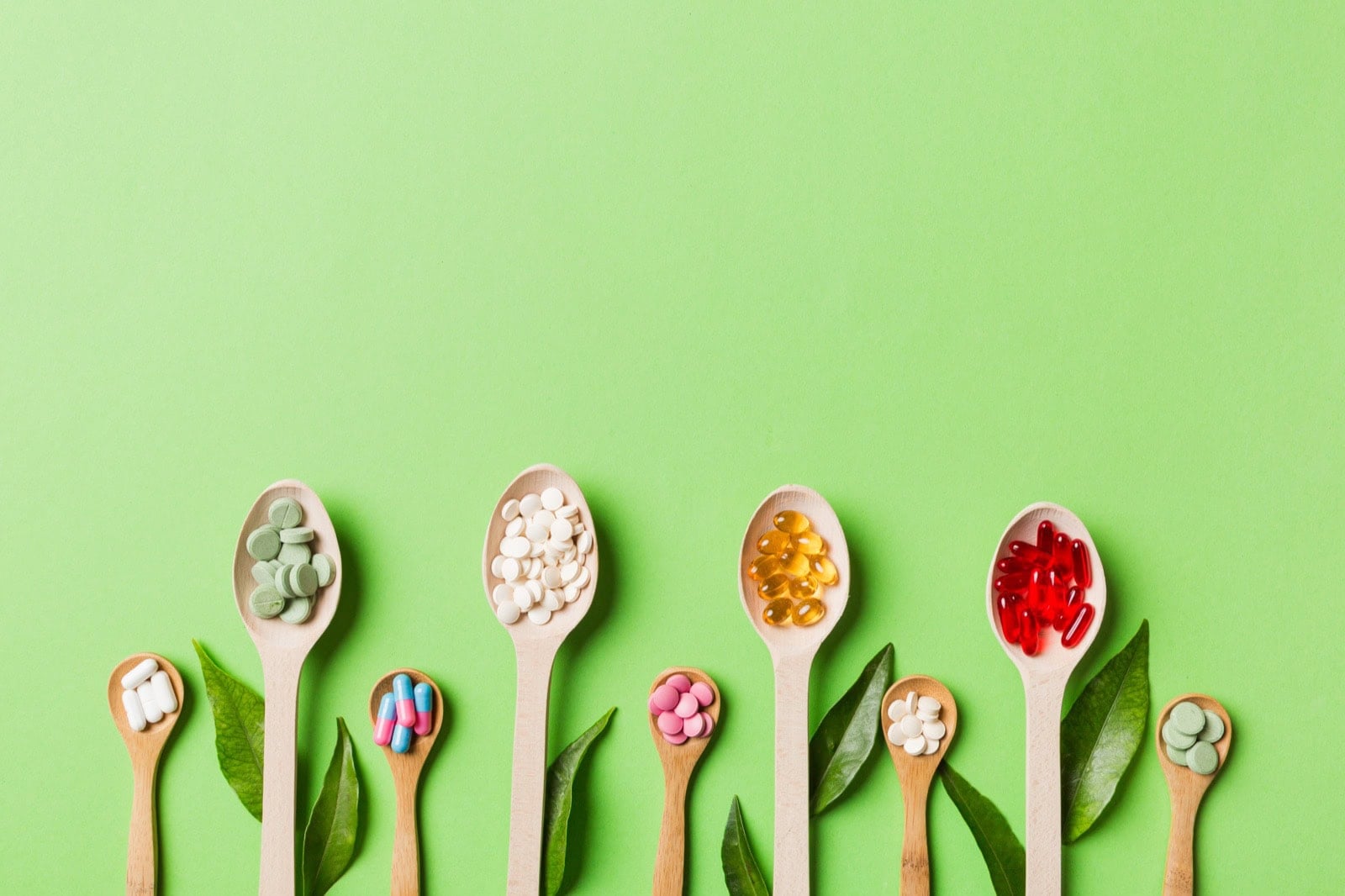 Verschiedene vegane Supplemente in Dosen und Fläschchen auf einer hellen Fläche