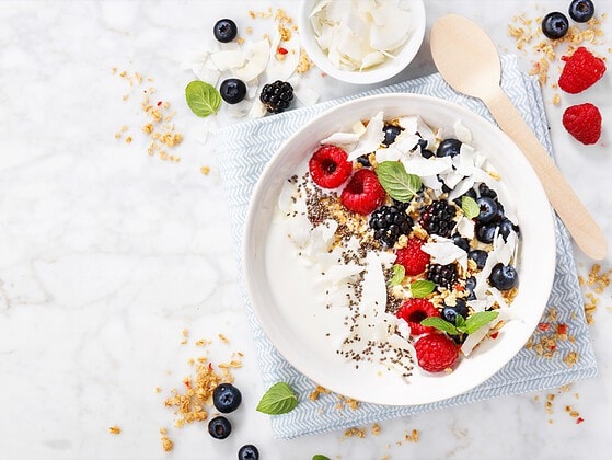 Pflanzlicher Joghurt mit frischen Beeren in einer Schale