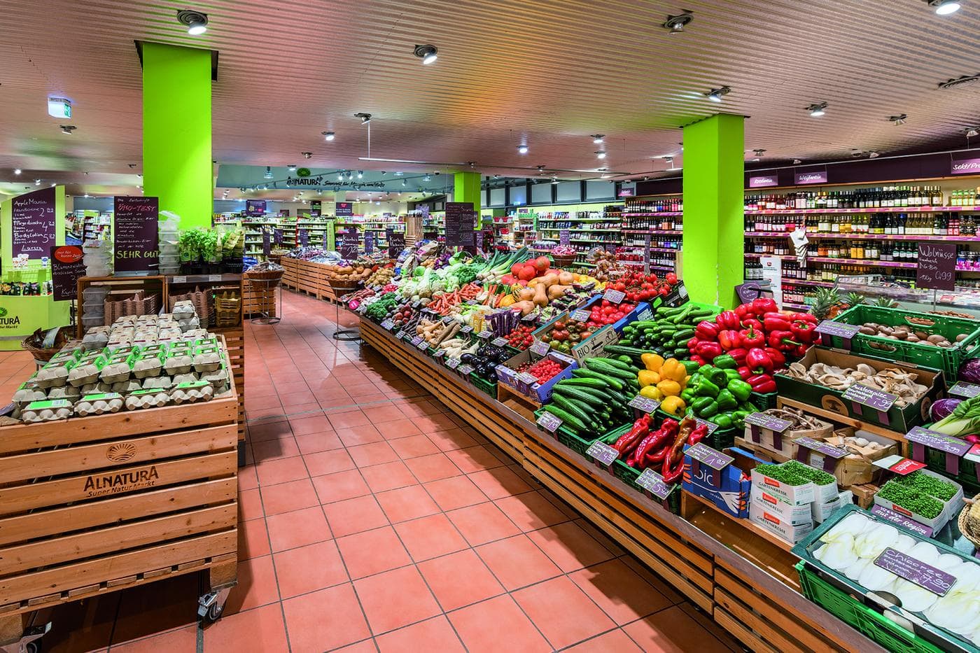Innenansicht des Alnatura Super Natur Markts in Berlin mit Obst- und Gemüseauslage