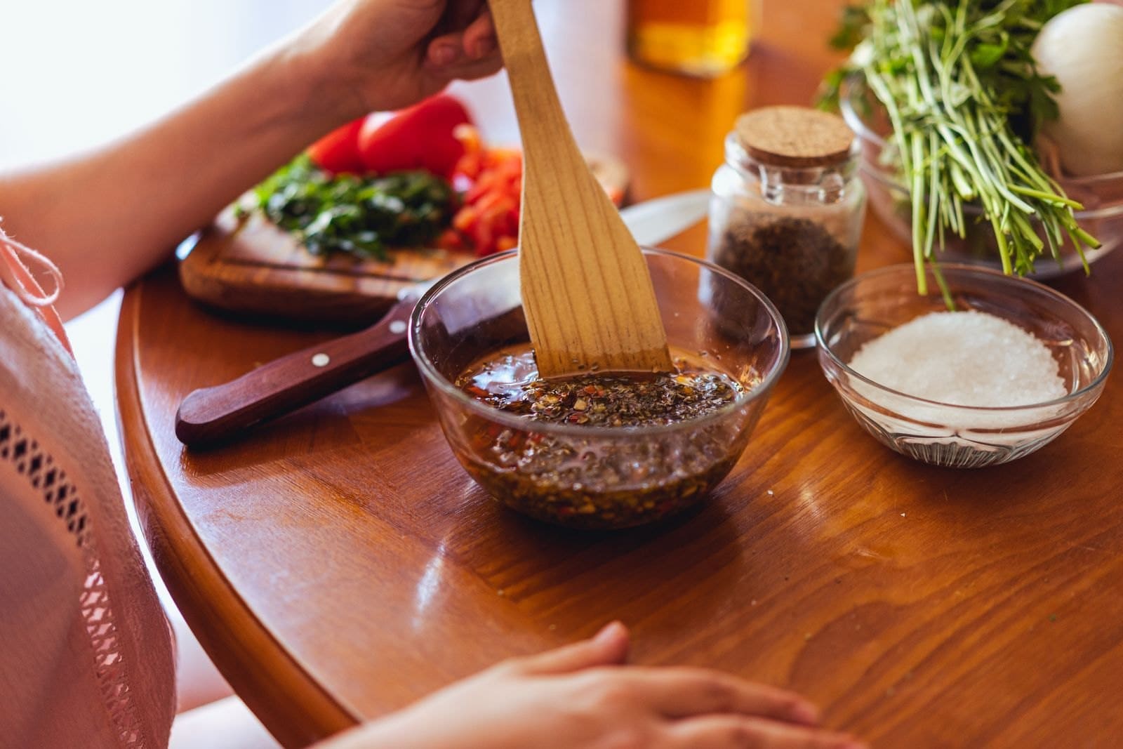 Marinade wird in einer Glasschüssel angerührt, daneben frische Kräuter und Gewürze