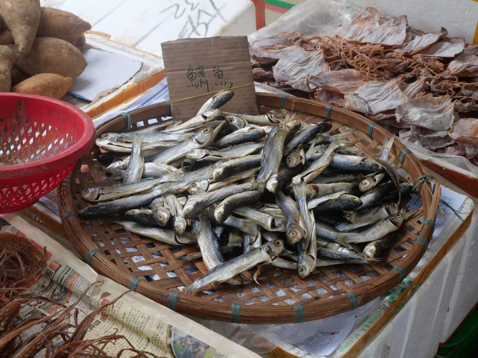 Getrockneter Kleinfisch in einem Bambuskorb auf einem asiatischen Marktstand