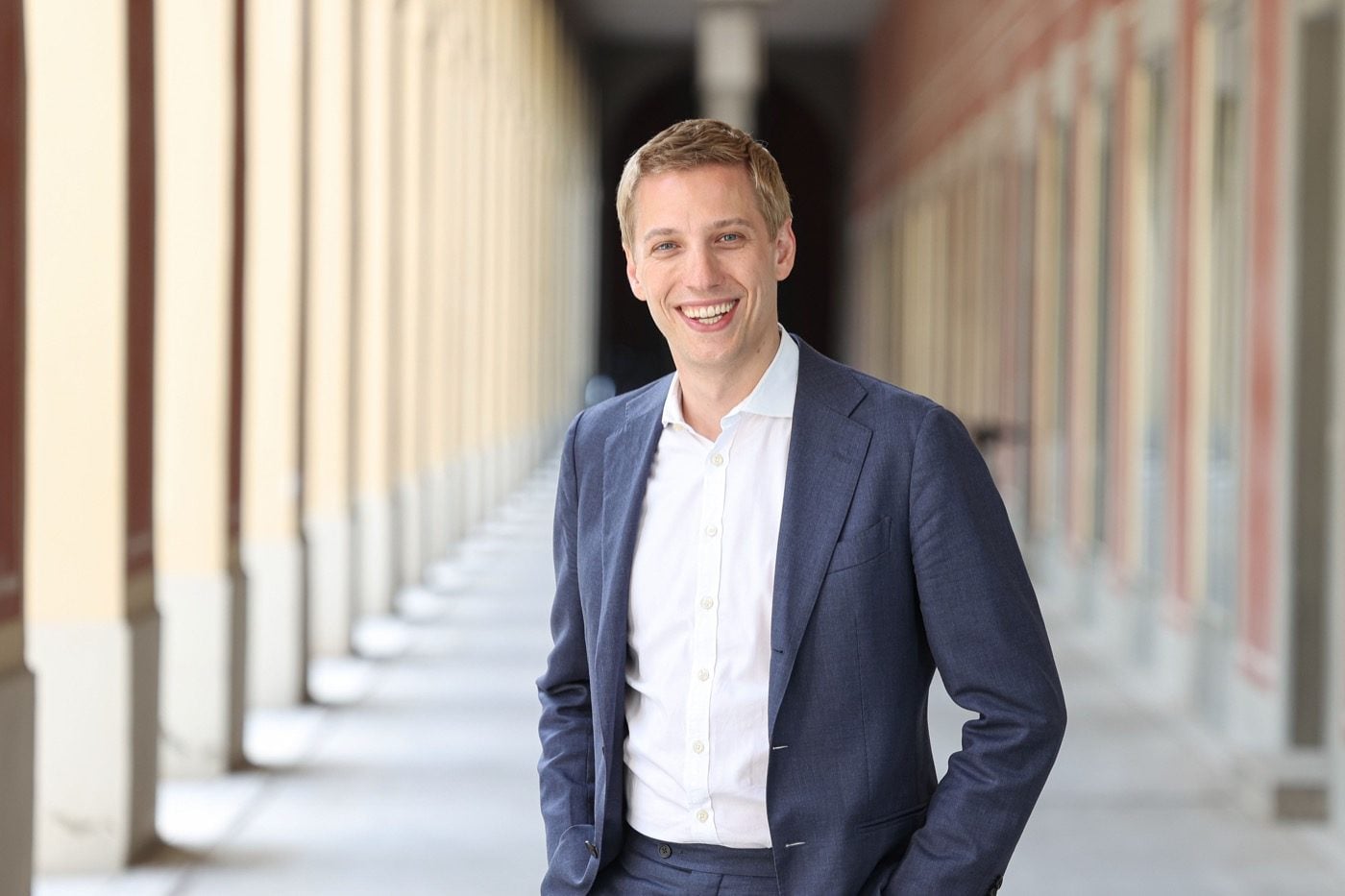 Dominik Krause, Oberbürgermeister von München, im Anzug in einem Arkadengang des Rathauses