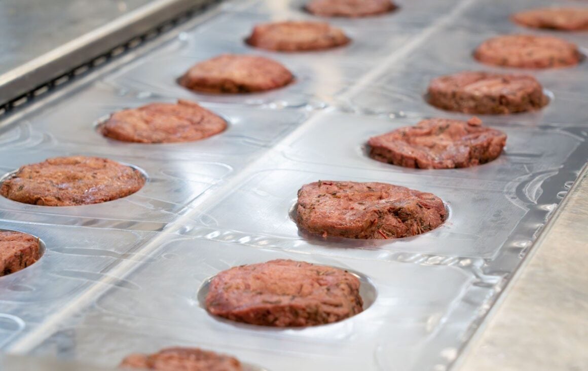 Pflanzliche Steaks von Planted liegen in Reihen auf einem Produktionsband