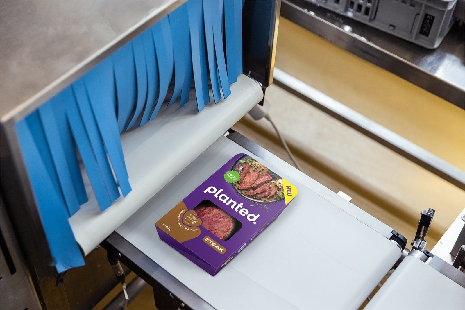 Eine Packung Planted Steak läuft durch die Verpackungsanlage im Werk Memmingen