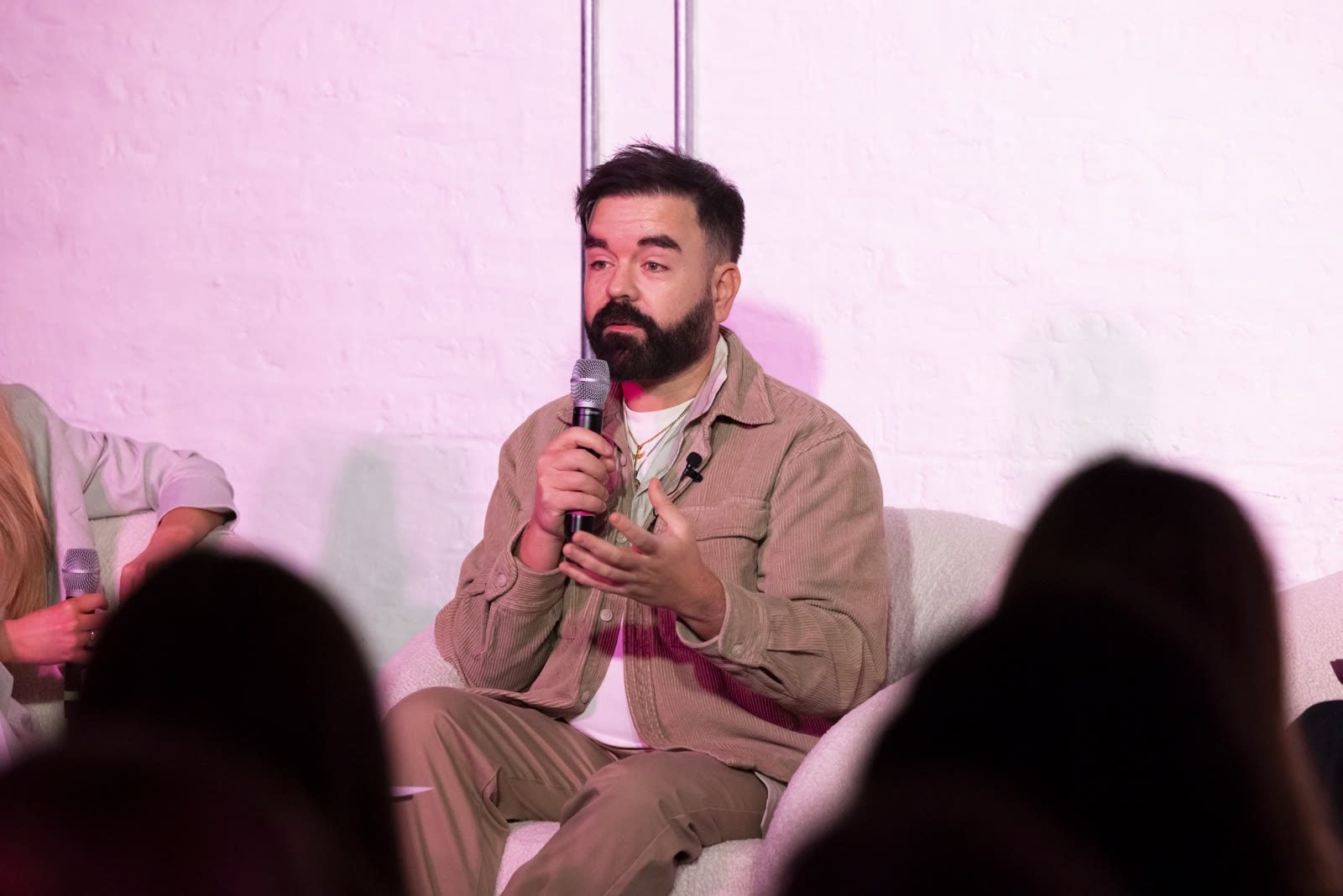 Robbie Lockie spricht mit Mikrofon auf der Bühne eines Panels bei einem veganen Event