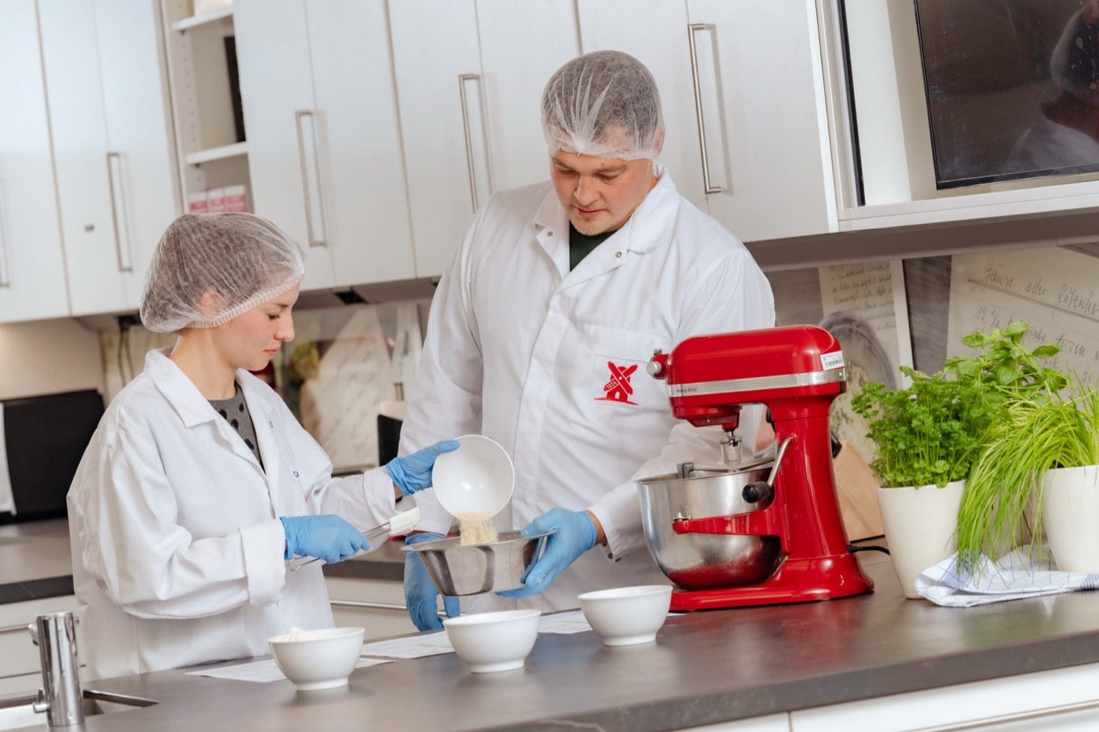 Zwei Personen in Laborkleidung arbeiten in der Entwicklungsküche der Rügenwalder Mühle an neuen Rezepturen