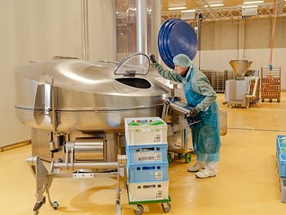 Mitarbeiterin an einem großen Kutter, in dem die Masse für den Veganen Schinken Spicker verarbeitet wird