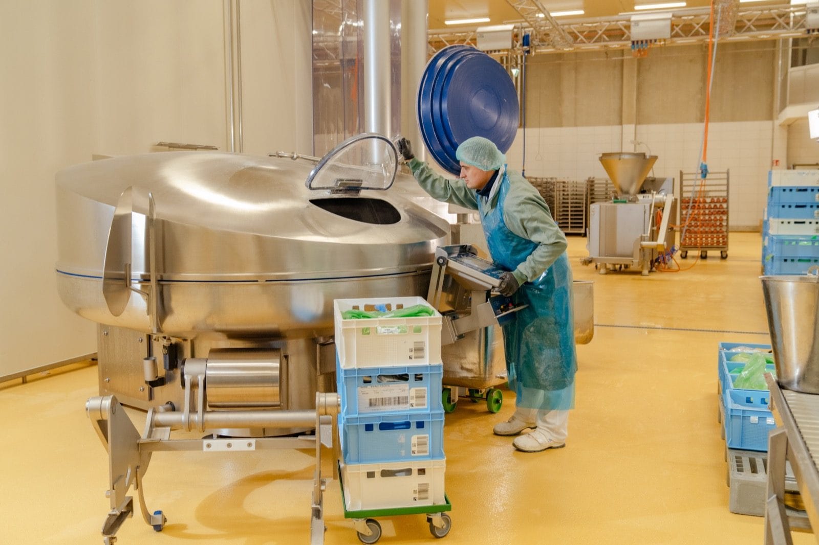 Mitarbeiterin an einem großen Kutter, in dem die Masse für den Veganen Schinken Spicker verarbeitet wird