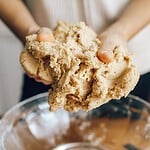 Seitan selber machen: Anleitung, Nährwerte und die häufigsten Fehler Haende heben einen zaehen Seitanteig aus einer Glasschuessel
