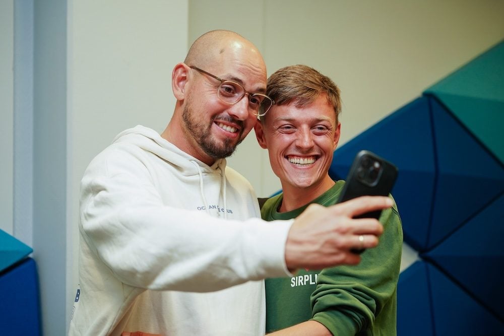 Zwei Teilnehmer machen ein Selfie beim SFT Festival, einer trägt ein SIRPLUS-Shirt