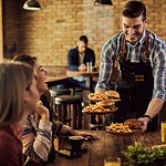 Ein Kartoffelkonzern erklärt der Gastronomie die pflanzliche Zukunft. Und liegt damit nicht falsch Kellner serviert Essen an einen Tisch mit fröhlicher Gruppe in einem Pub
