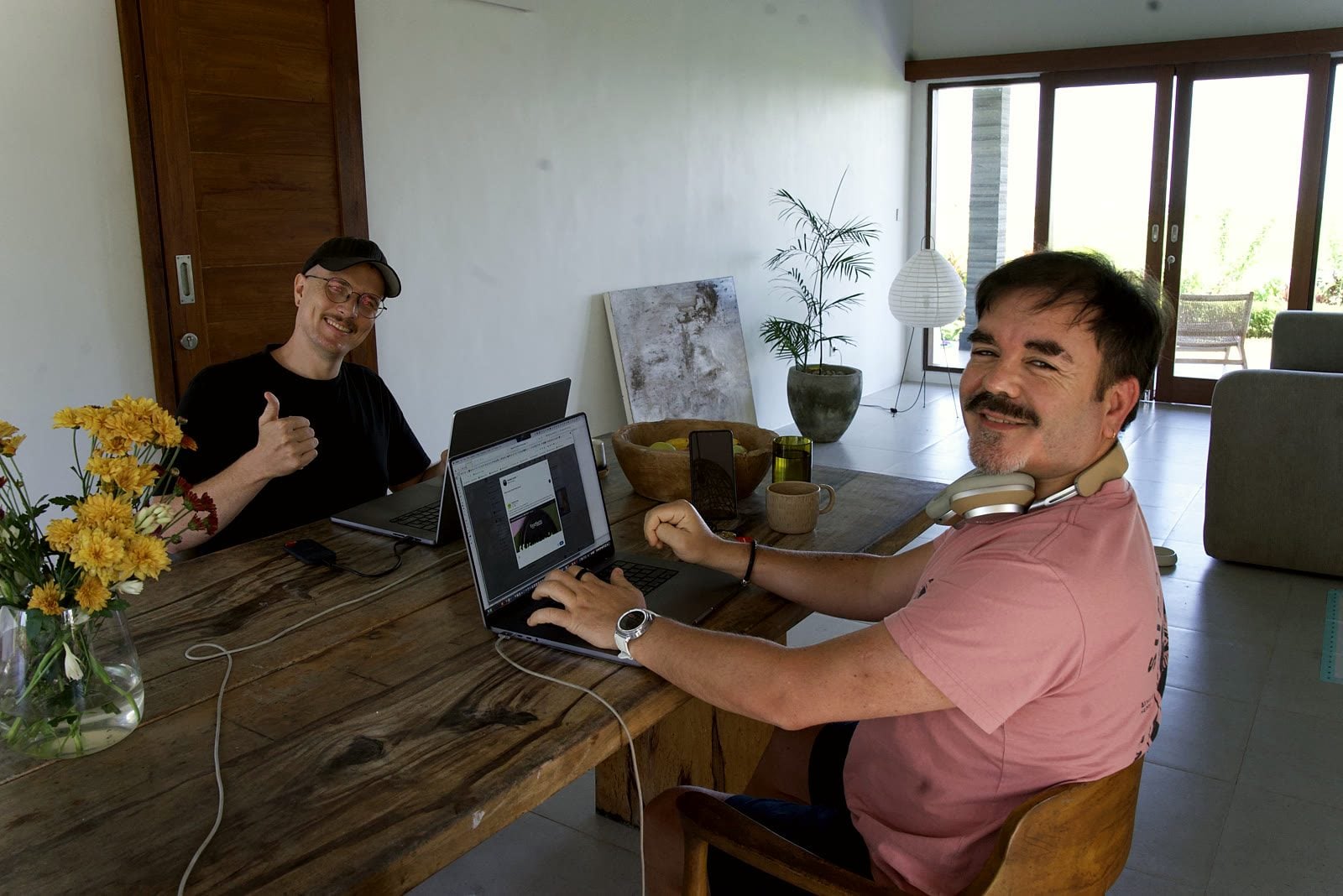 Robbie Lockie und Yannick Haldenwanger schauen beim Co-Working auf Bali lachend in die Kamera