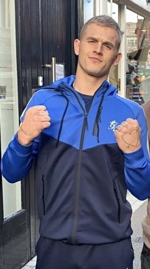 Ian Machado Garry in blauem Trainingsanzug mit erhobenen Fäusten