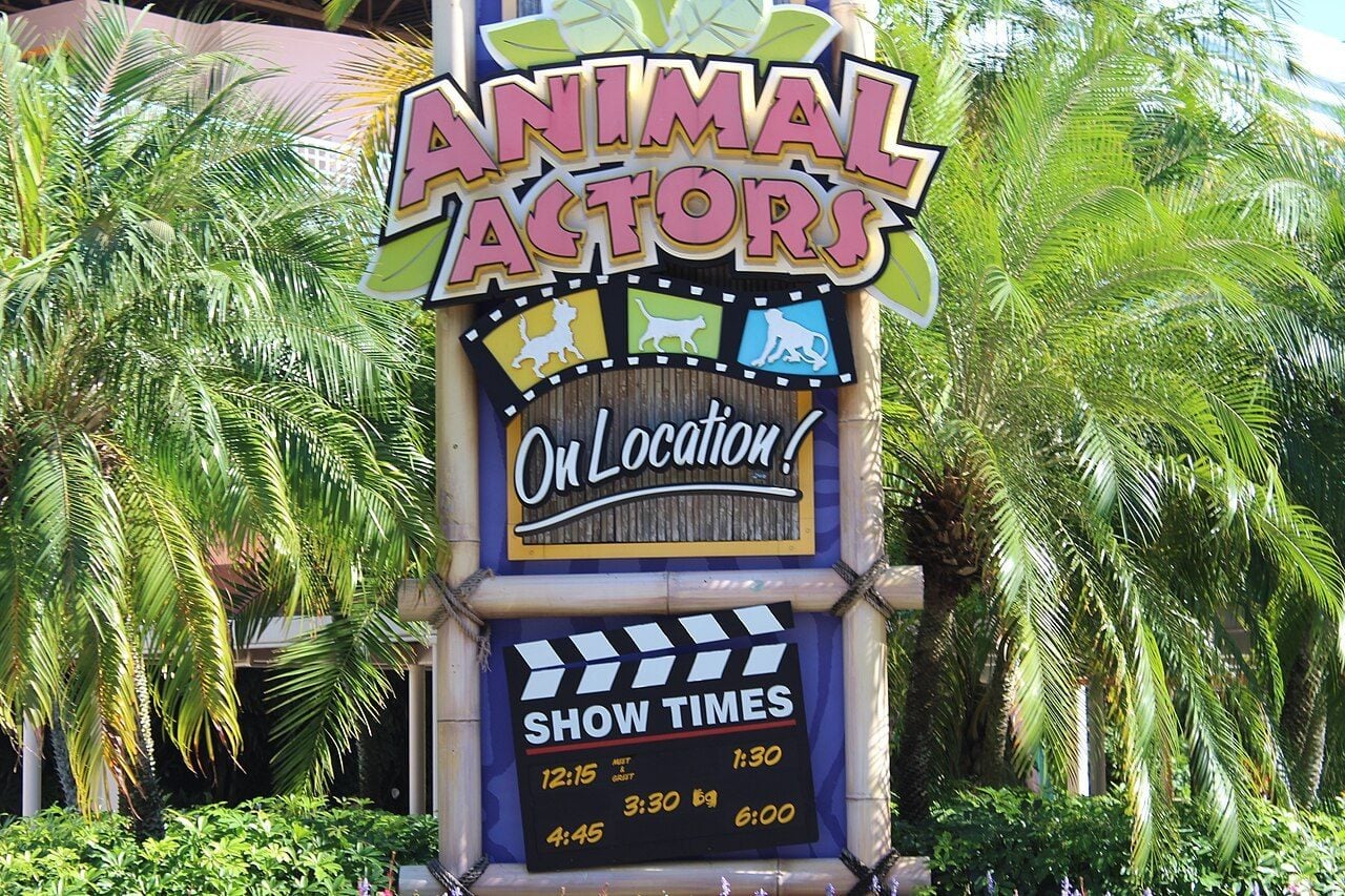 Buntes Schild der Show Animal Actors On Location im Universal Studios Florida mit Vorführzeiten