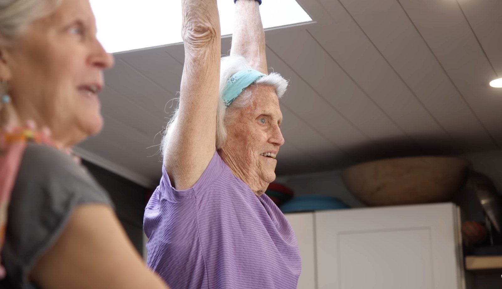Ann Esselstyn hebt in ihrer Küche einen Arm, ihre Tochter Jane steht daneben