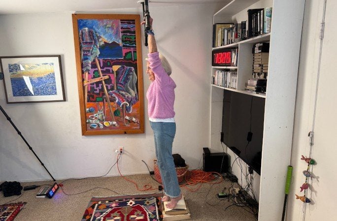 Ann Esselstyn steht vor dem Rekordversuch auf einem Bücherstapel unter der Klimmzugstange