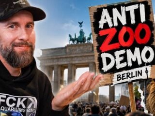 Robert Marc Lehmann vor dem Brandenburger Tor mit Schild Anti Zoo Demo Berlin