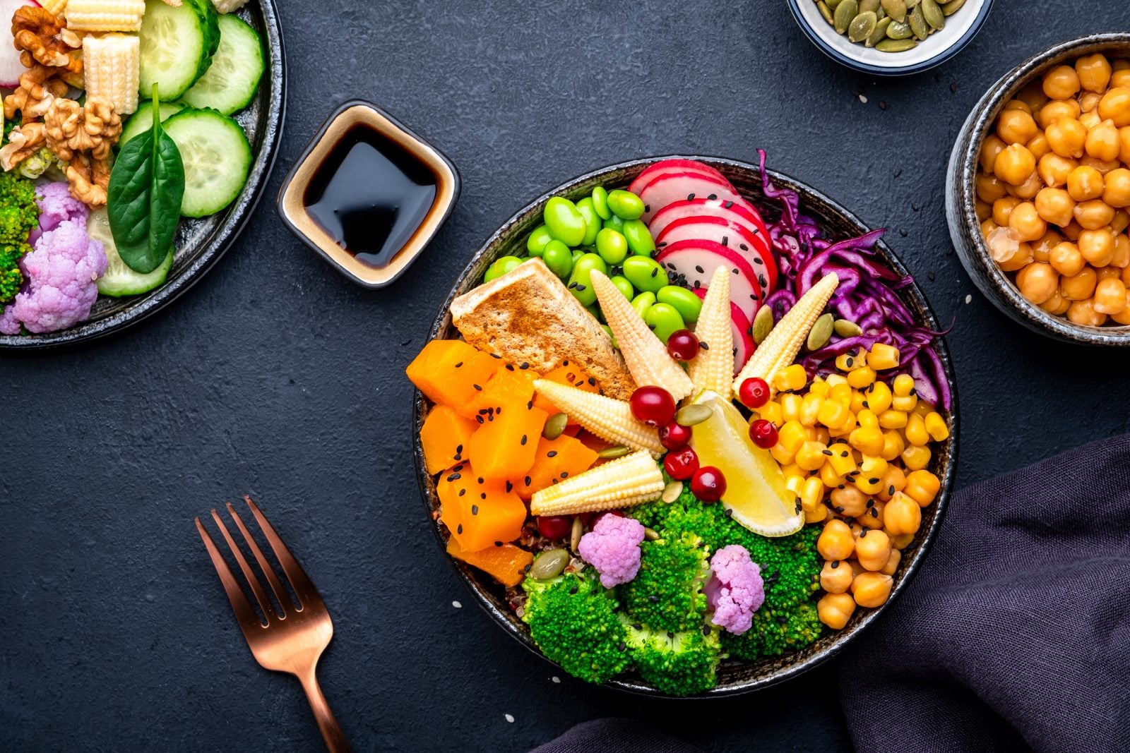 Vegane Bowl mit Süßkartoffel, Quinoa, Kichererbsen, Edamame, Tofu, Brokkoli und Saaten von oben