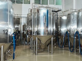 Edelstahl-Fermentationstanks in einer Produktionshalle, Symbolbild für Investitionen in Präzisionsfermentation