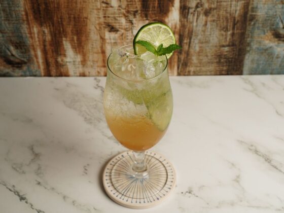 Alkoholfreier Hugo mit Eis, Limette und Minze im Stielglas