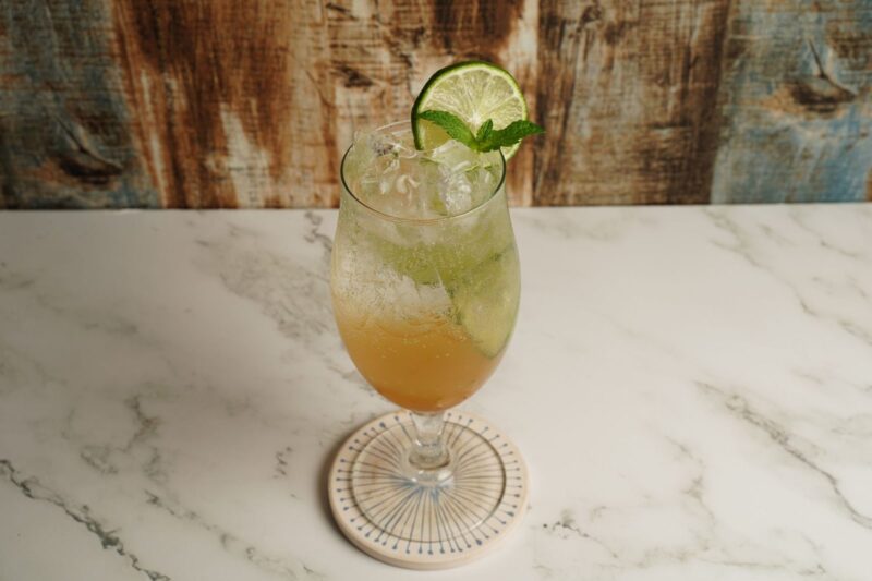 Alkoholfreier Hugo mit Eis, Limette und Minze im Stielglas