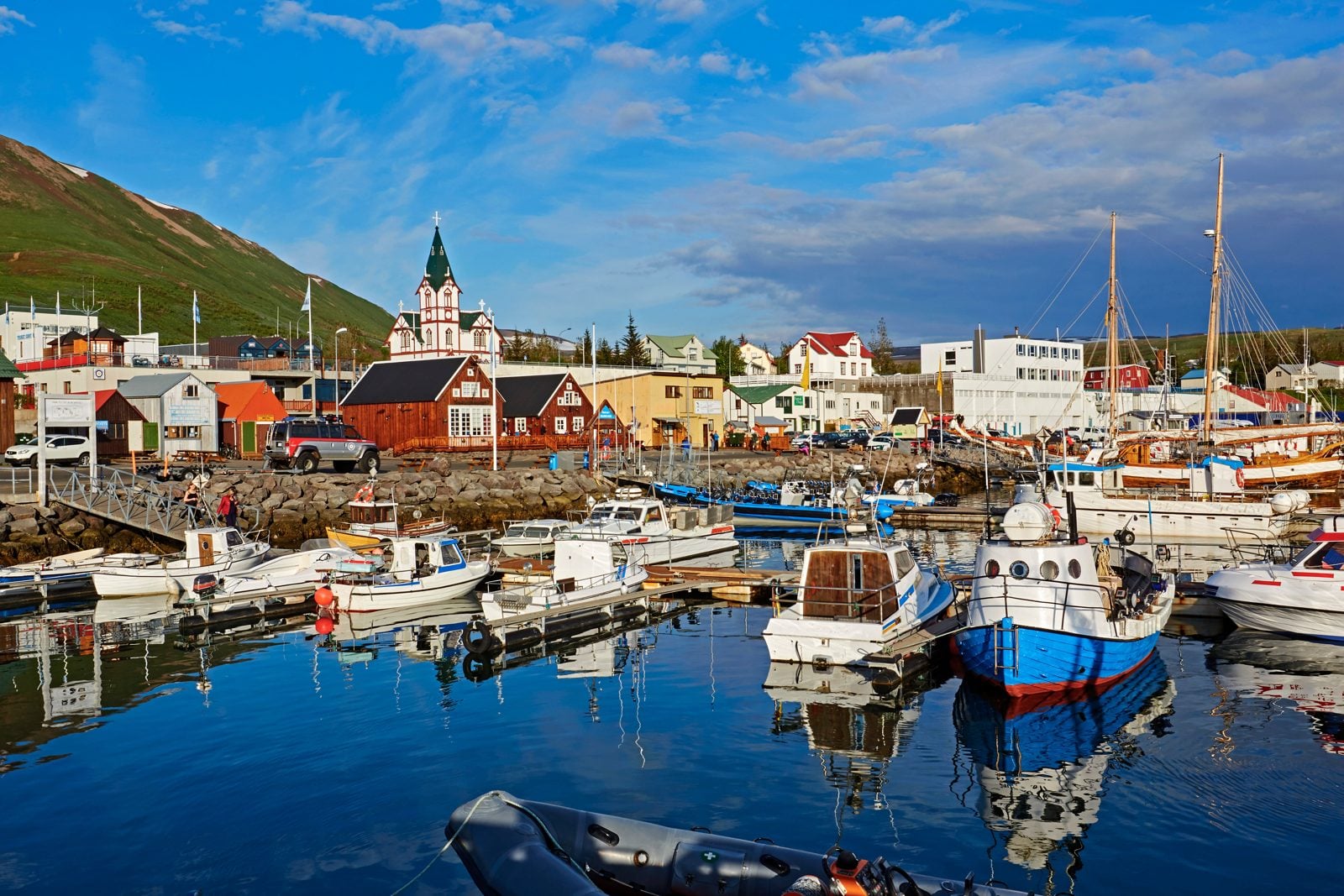 Harbour of Húsavík with colourful houses, church and boats
