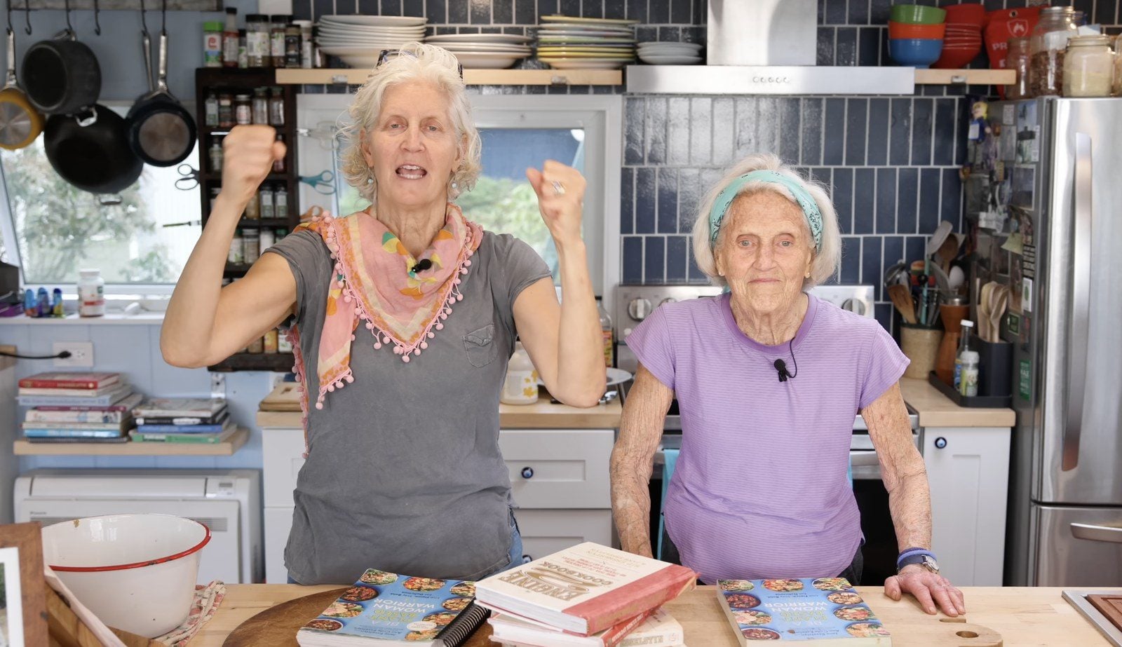 Jane und Ann Esselstyn stehen in ihrer Küche hinter Kochbüchern und jubeln in die Kamera
