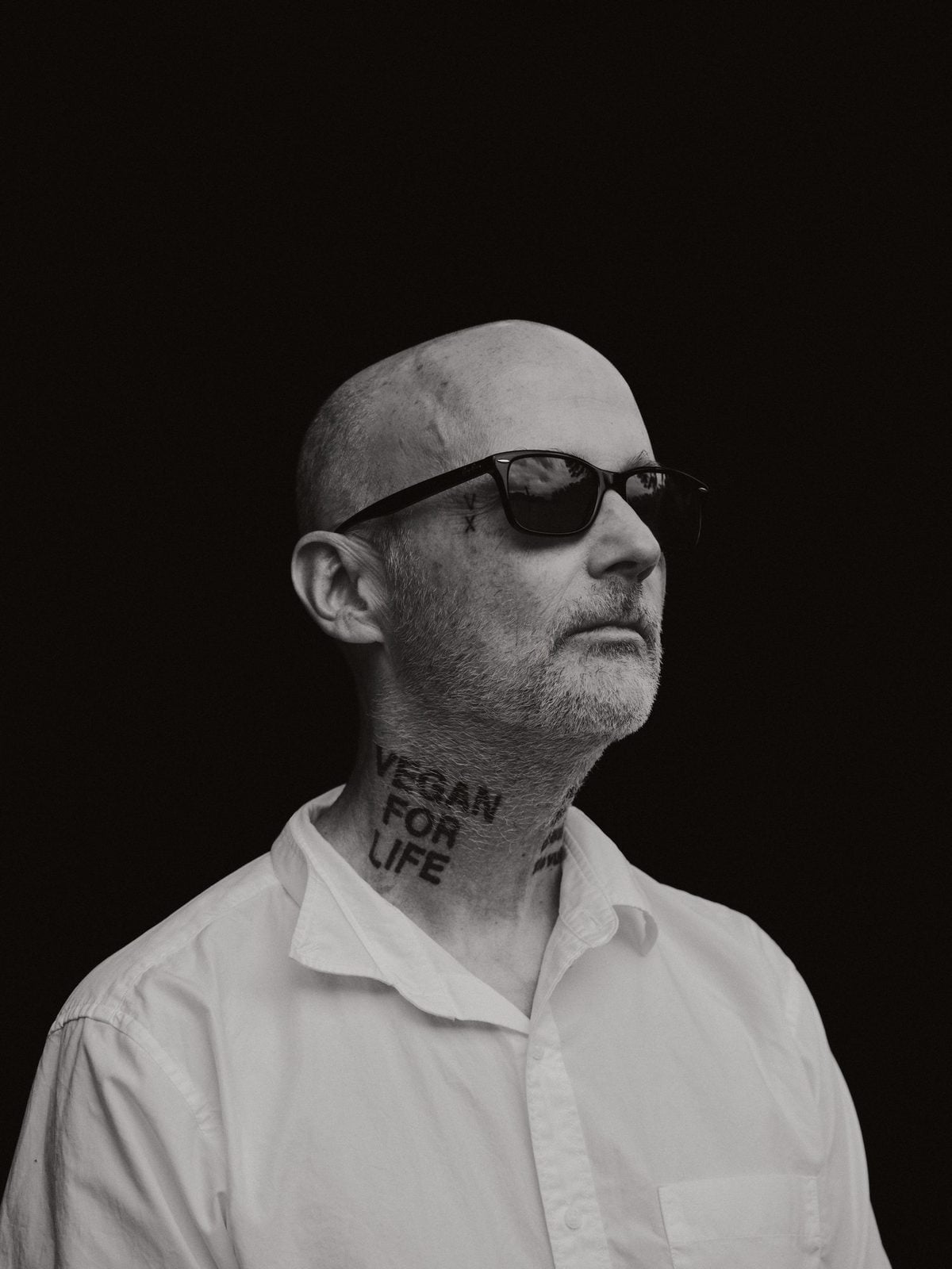 Schwarz-Weiß-Porträt von Moby mit dem Tattoo Vegan for Life am Hals